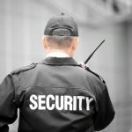 Male security guard using portable radio outdoors Security Guard